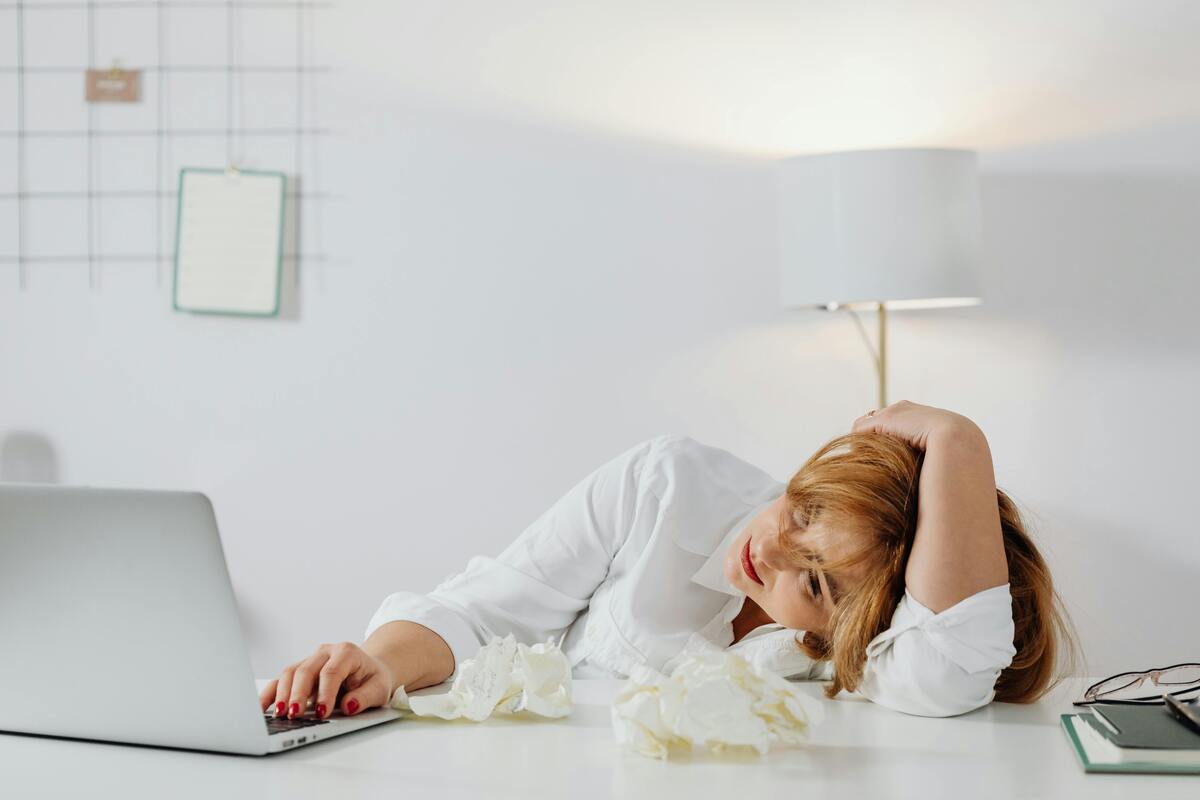 bored woman slumped on her desk looking at a laptop, how to make work go by faster